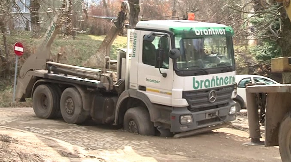 VIDEO Două camioane de salubritate au fost îngropate in namol pe o stradă din Reşiţa